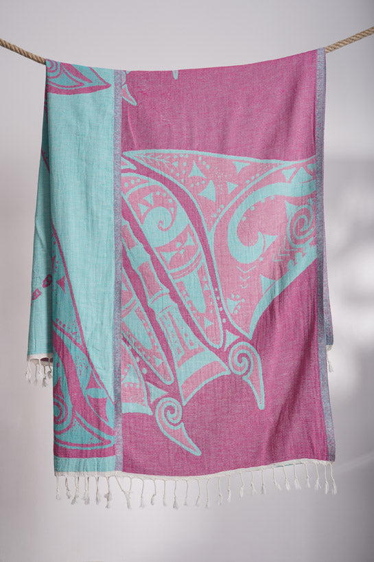 Pink and teal patterned scarf with fringe on a white background