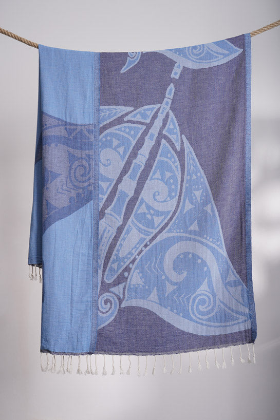 Blue and white patterned scarf with fringes on a gray background