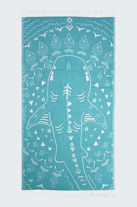 Teal towel with white shark design and geometric patterns on a white background