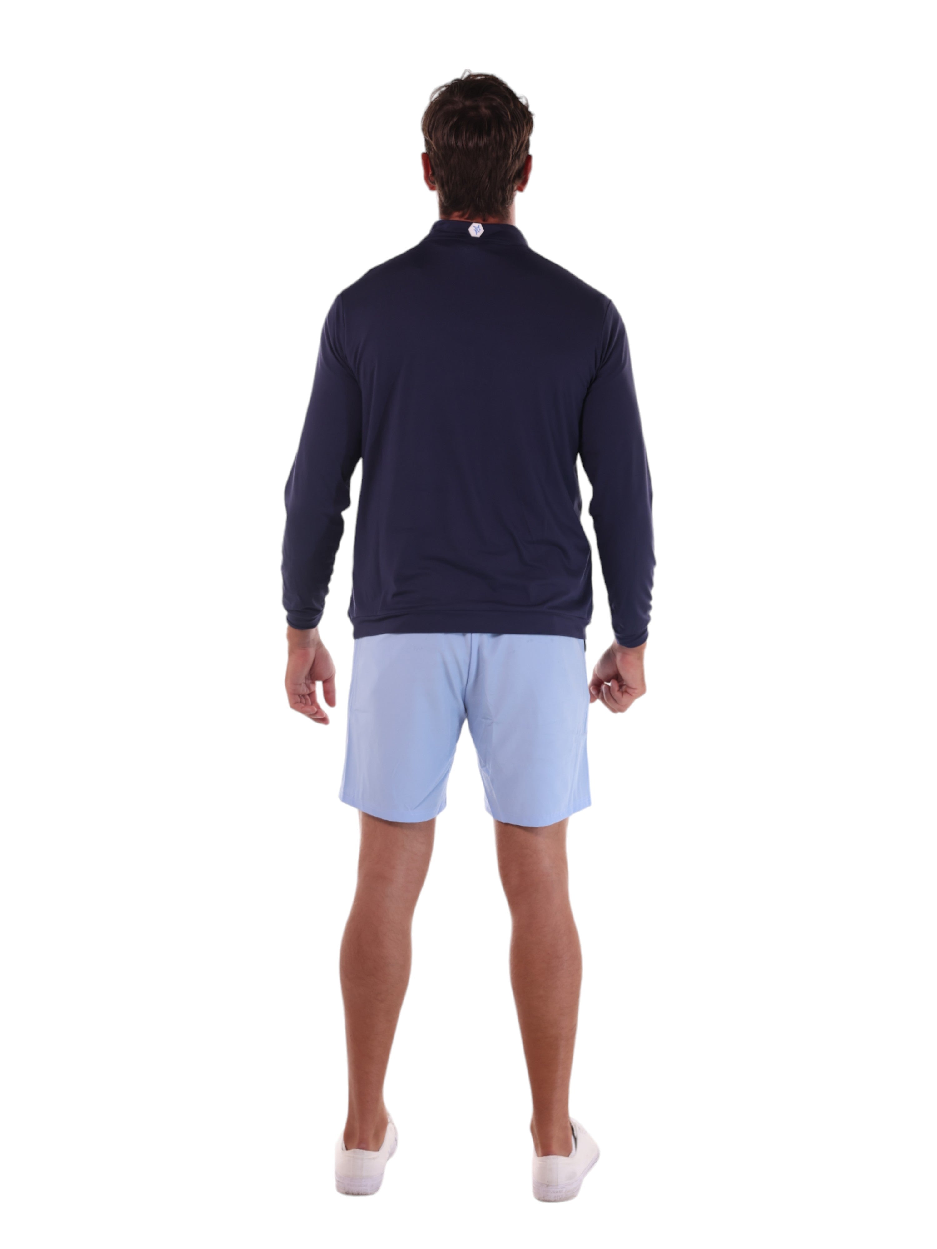 Man wearing a navy long-sleeve shirt and light blue shorts on a white background
