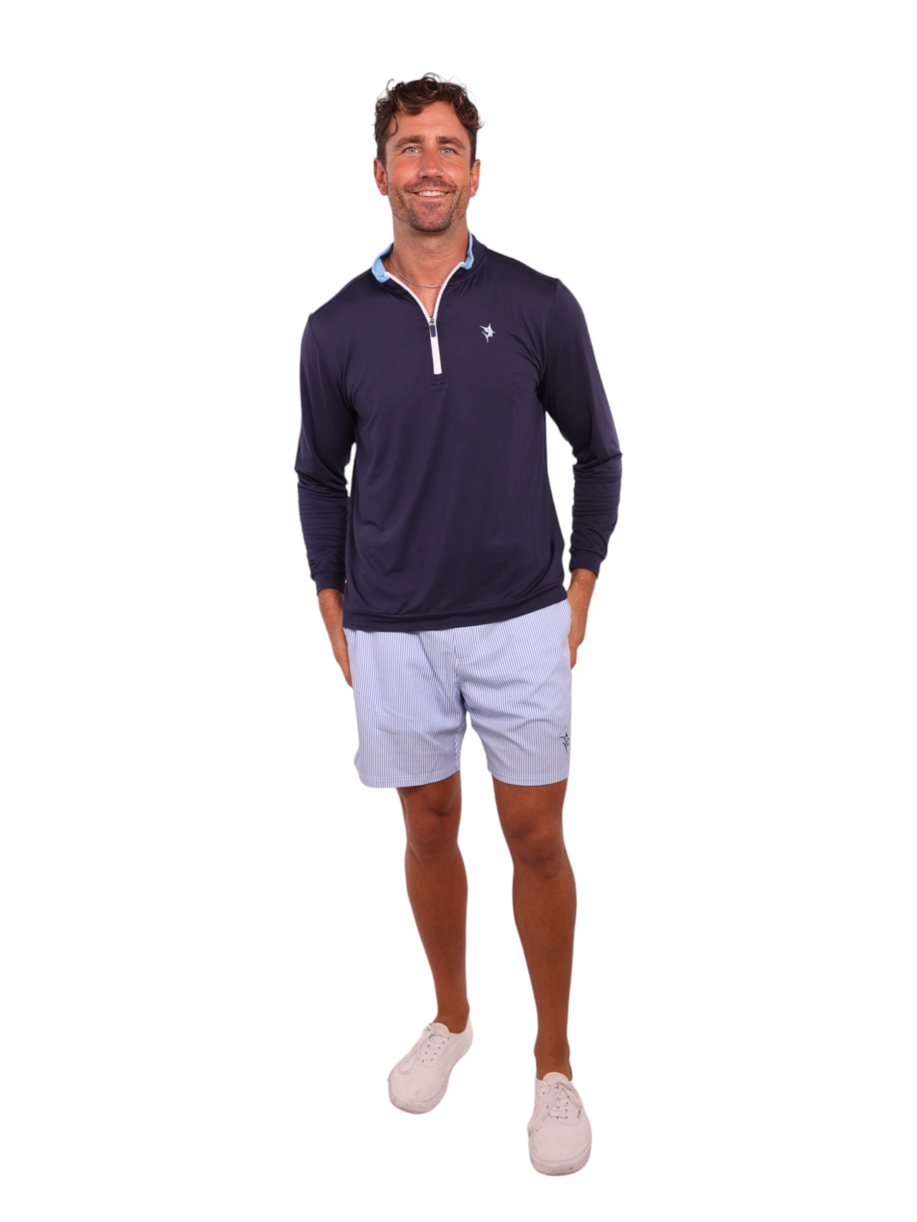 Man wearing a navy long-sleeve shirt and light blue shorts on a white background