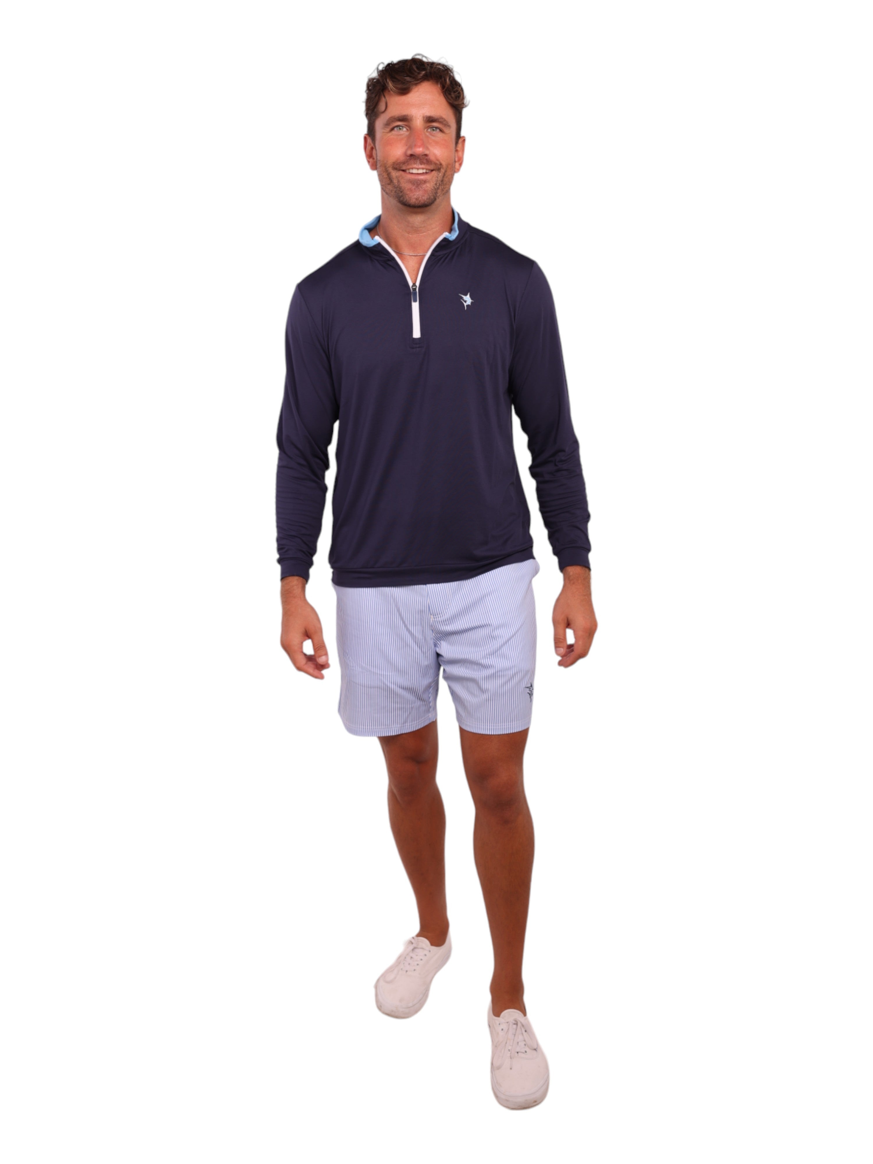 Man wearing a navy long-sleeve shirt and light gray shorts on a white background