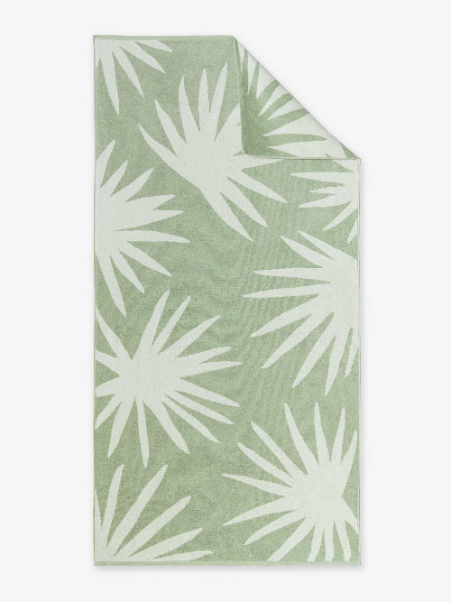 Folded green fabric with white palm leaf pattern on a white background