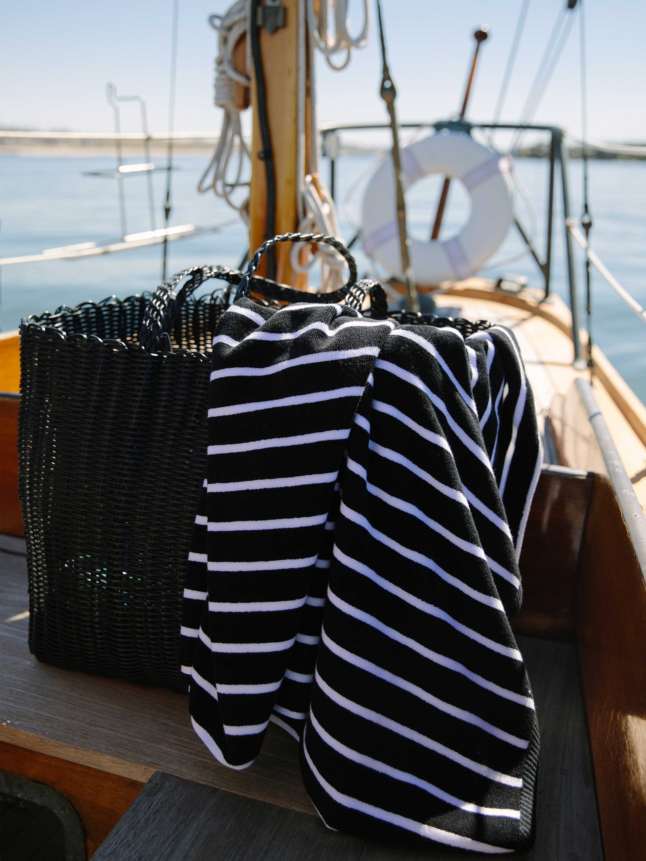 Black and white striped shirt on a hanger with a sailboat in the background