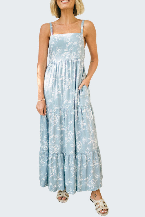 Woman wearing a light blue floral dress against a white background