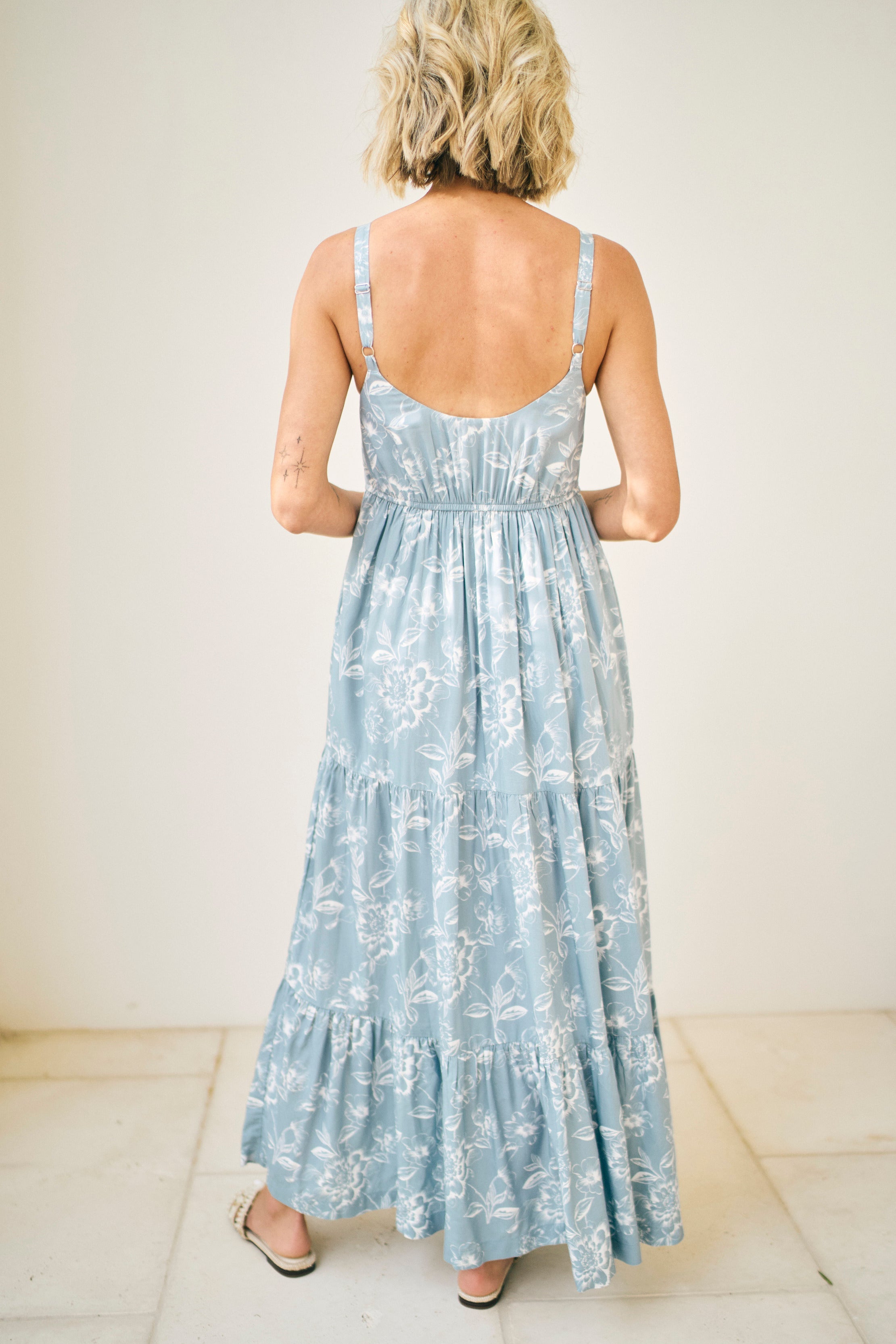 Woman wearing a light blue floral dress with a white background