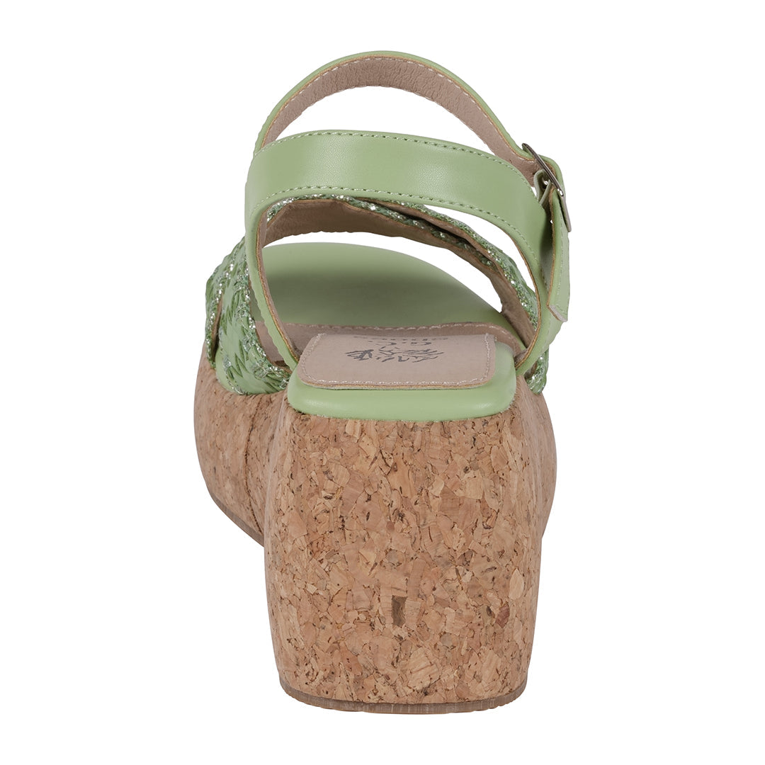 Green sandal with cork wedge sole on a white background