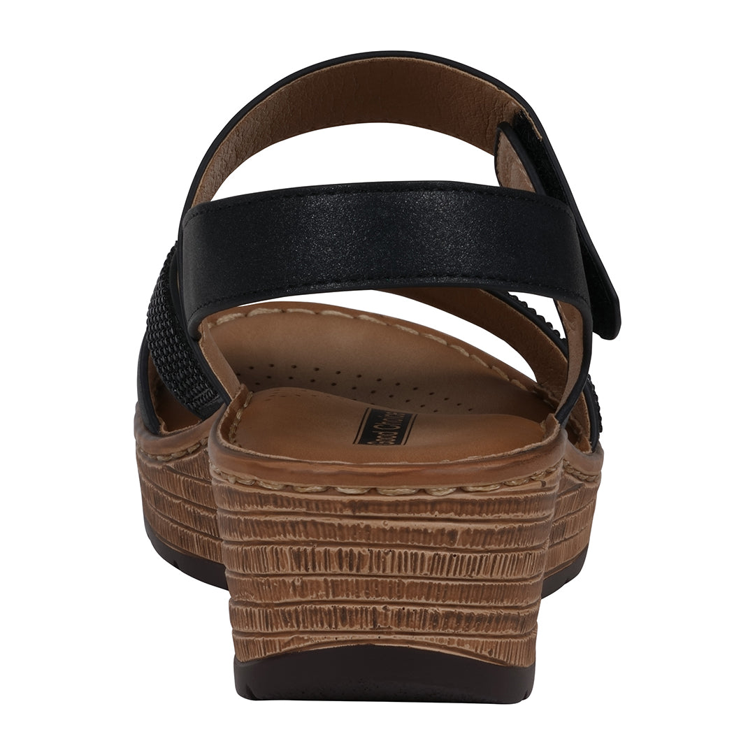 Black sandal with brown sole on a white background