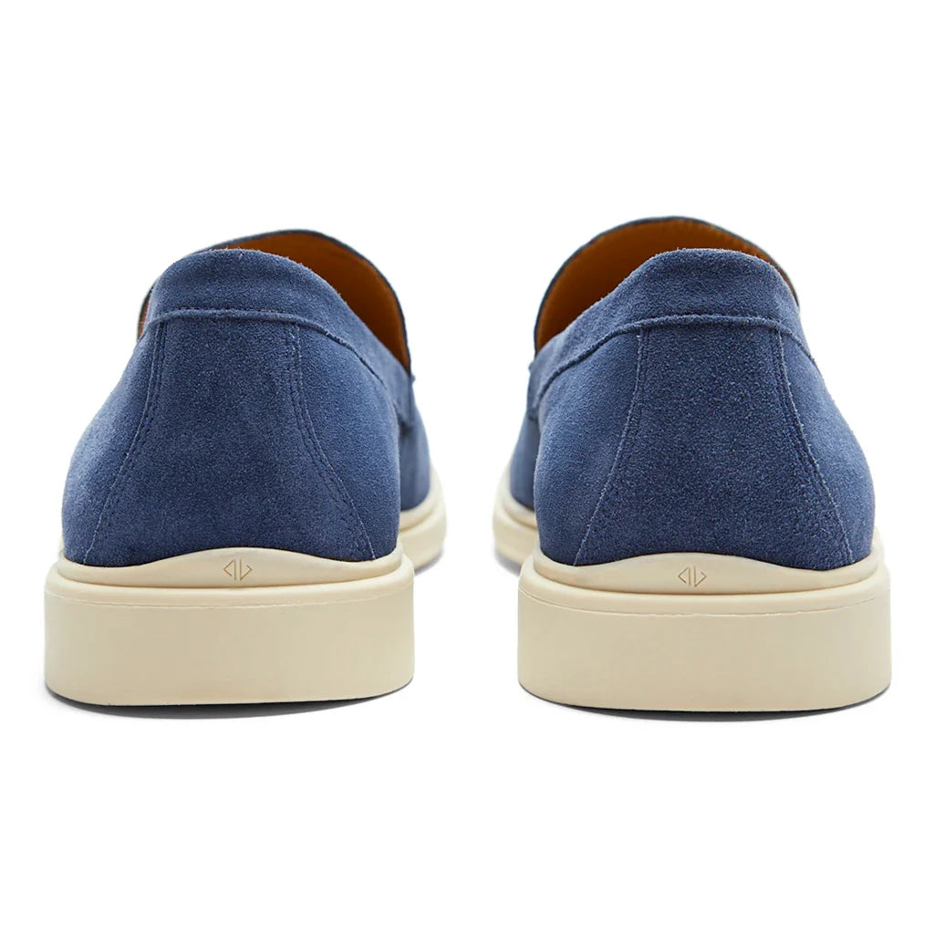 Blue slip-on shoes with beige soles on a white background