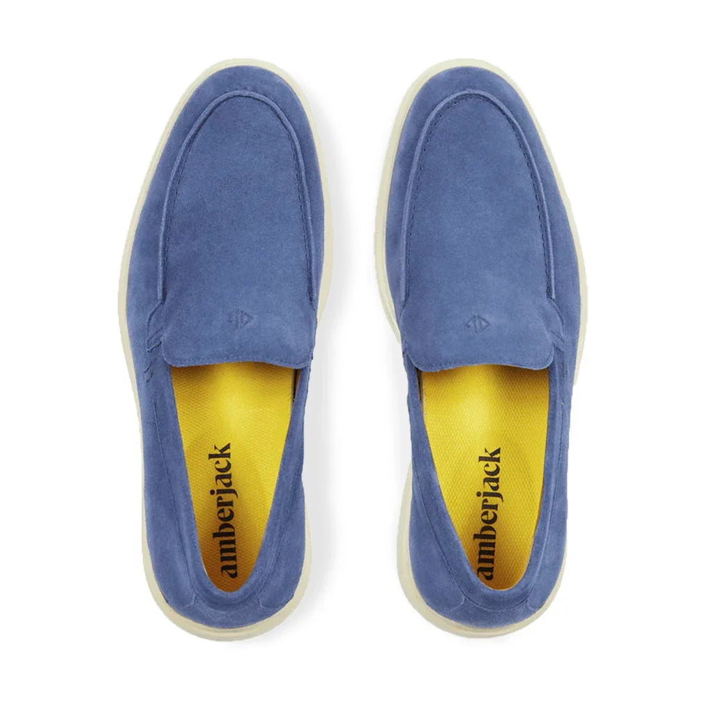 Blue slip-on shoes with yellow lining on a white background