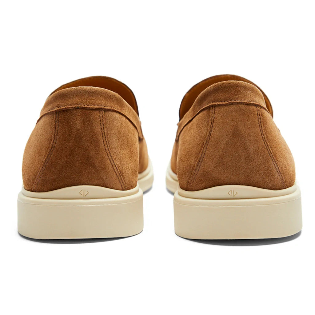 Brown suede loafers with white soles on a white background