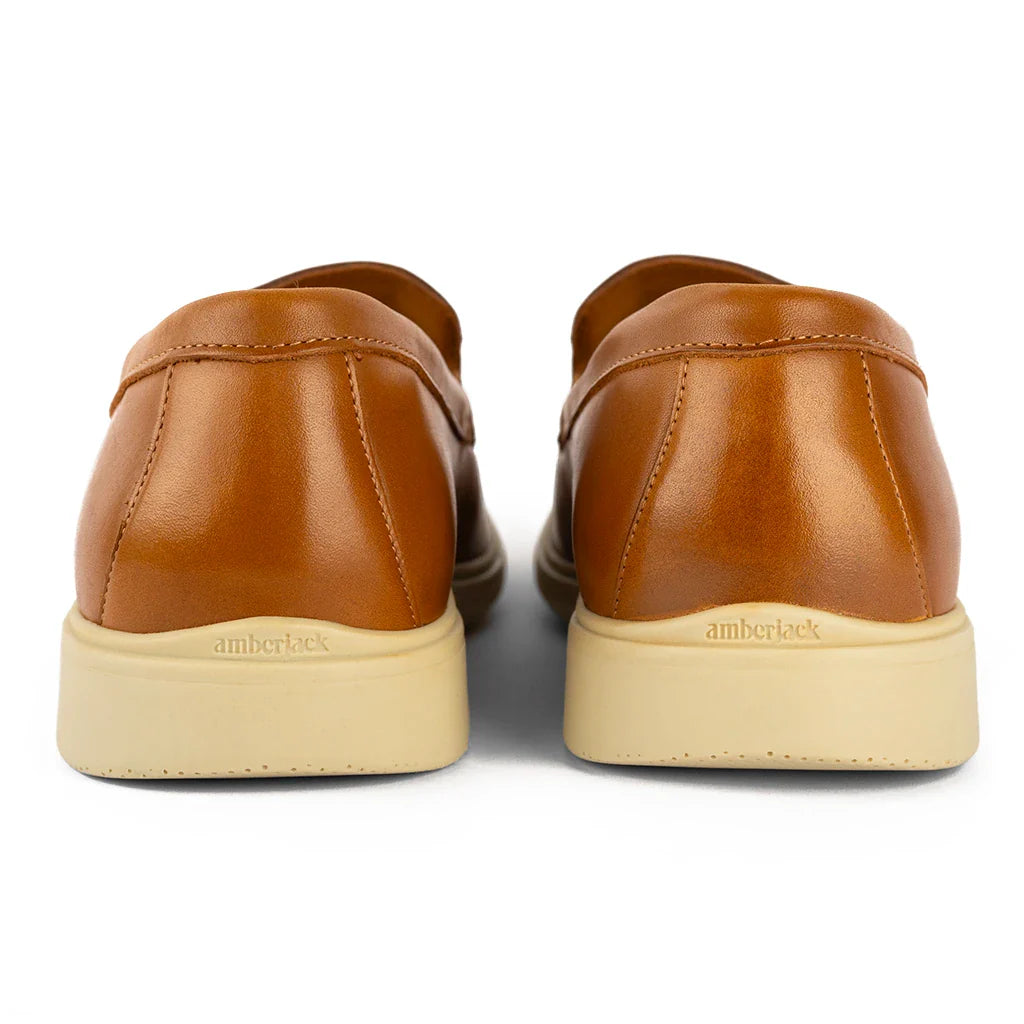 Pair of brown leather shoes with beige soles on a white background