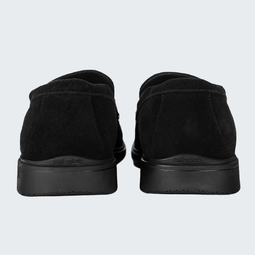 Black slip-on shoes with a brand logo on a white background