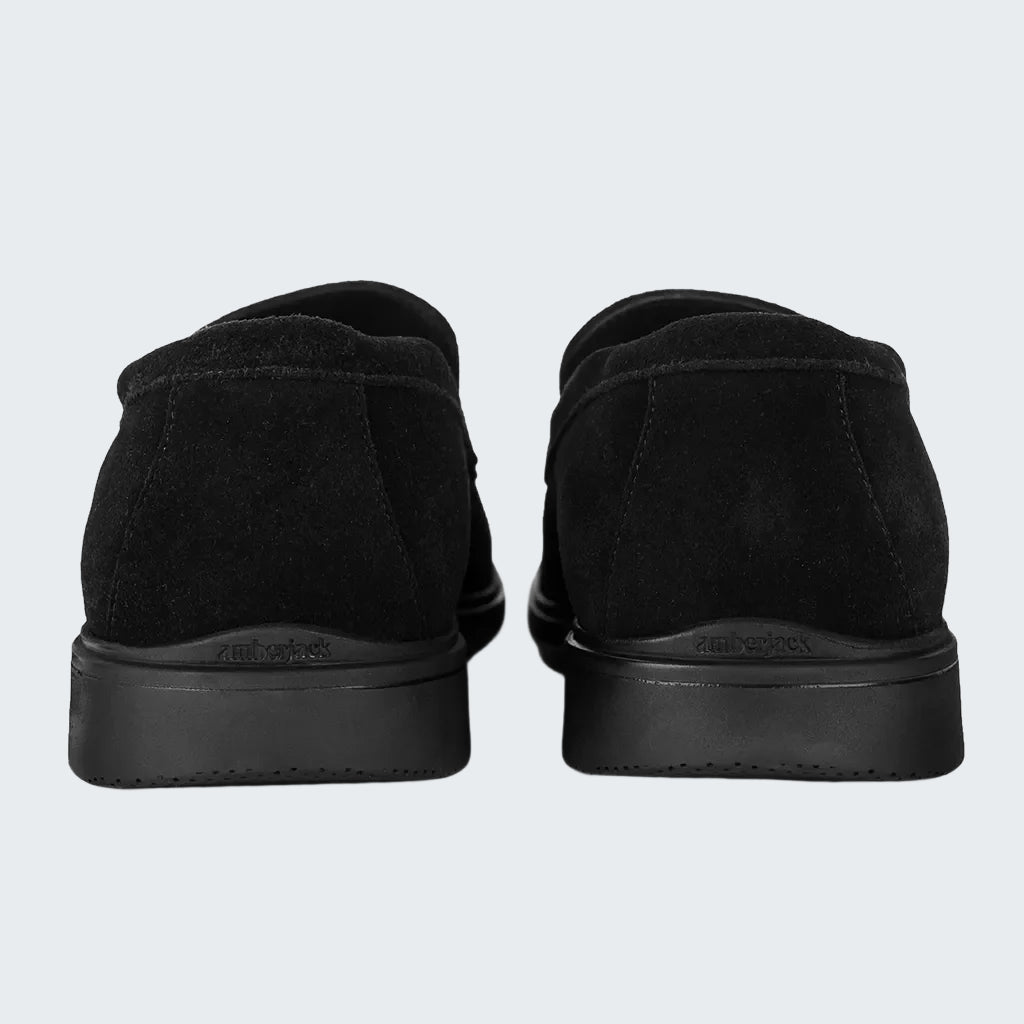 Black slip-on shoes with a brand logo on a white background