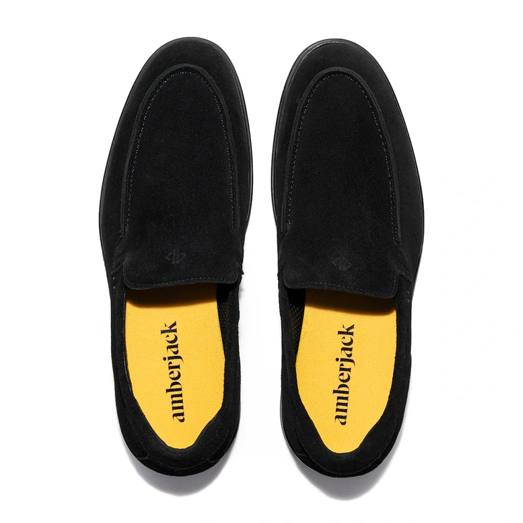 Black suede loafers with yellow insole displaying 'amberjack' branding on a white background