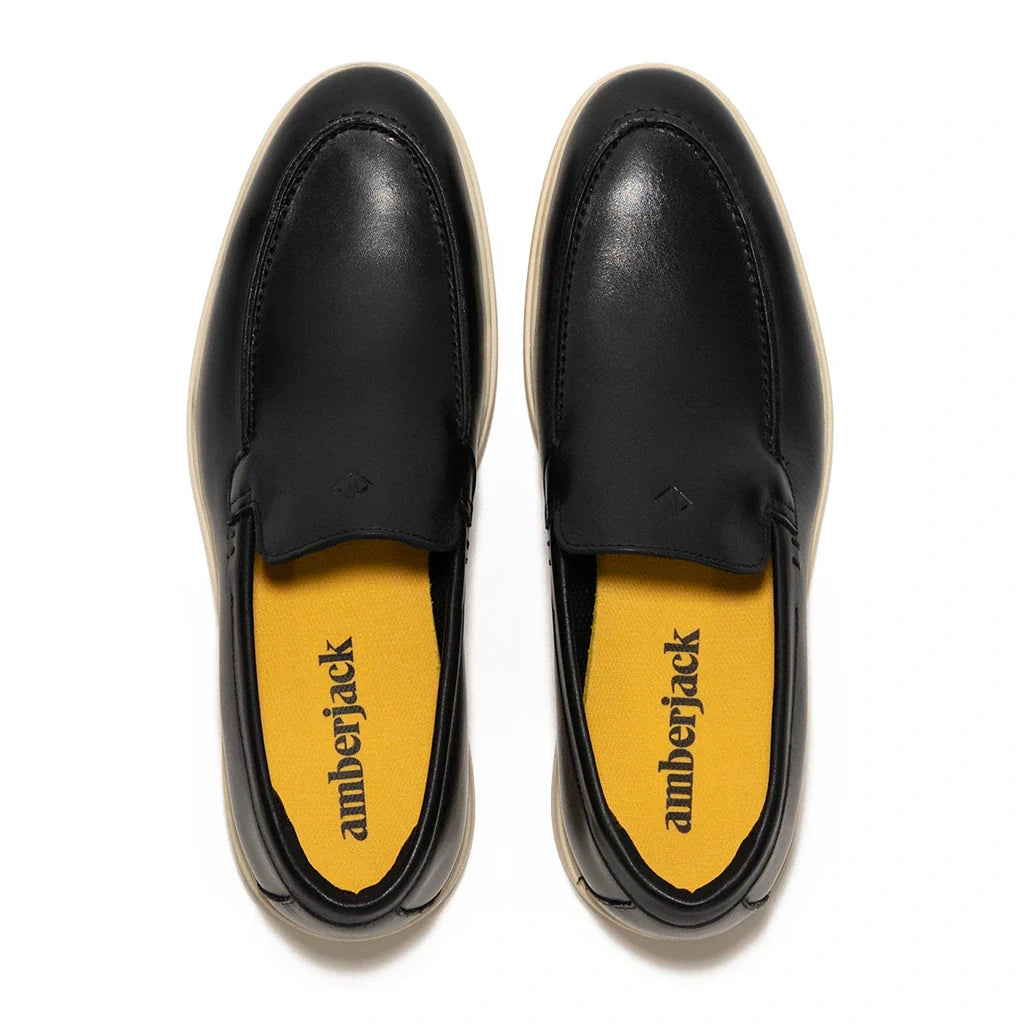 Black loafers with yellow insole displaying 'amberjack' branding on a white background
