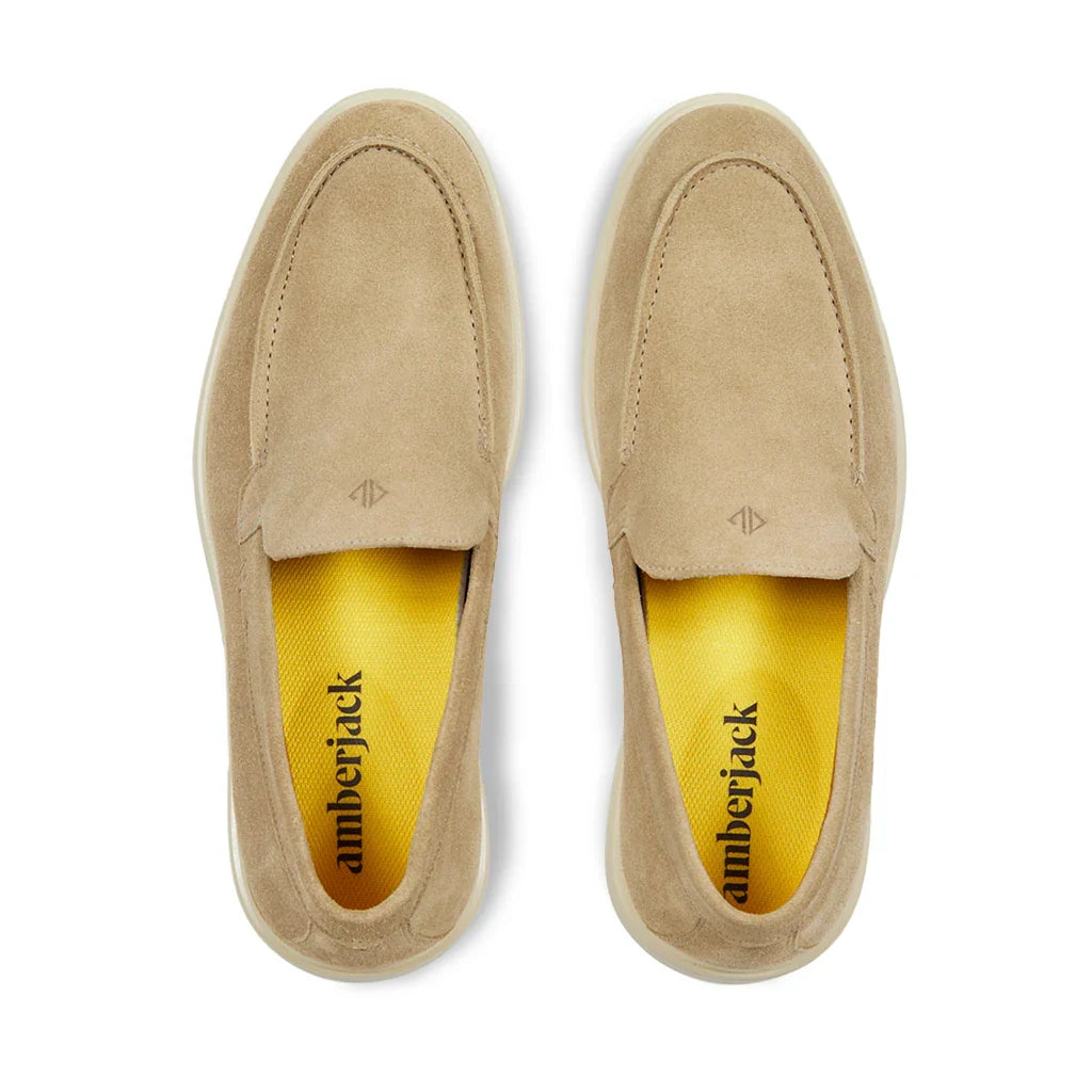 Pair of beige loafers with 'amberjack' branding on a white background