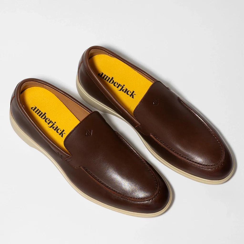 Brown loafers with yellow interior and 'amberjack' branding on a white background