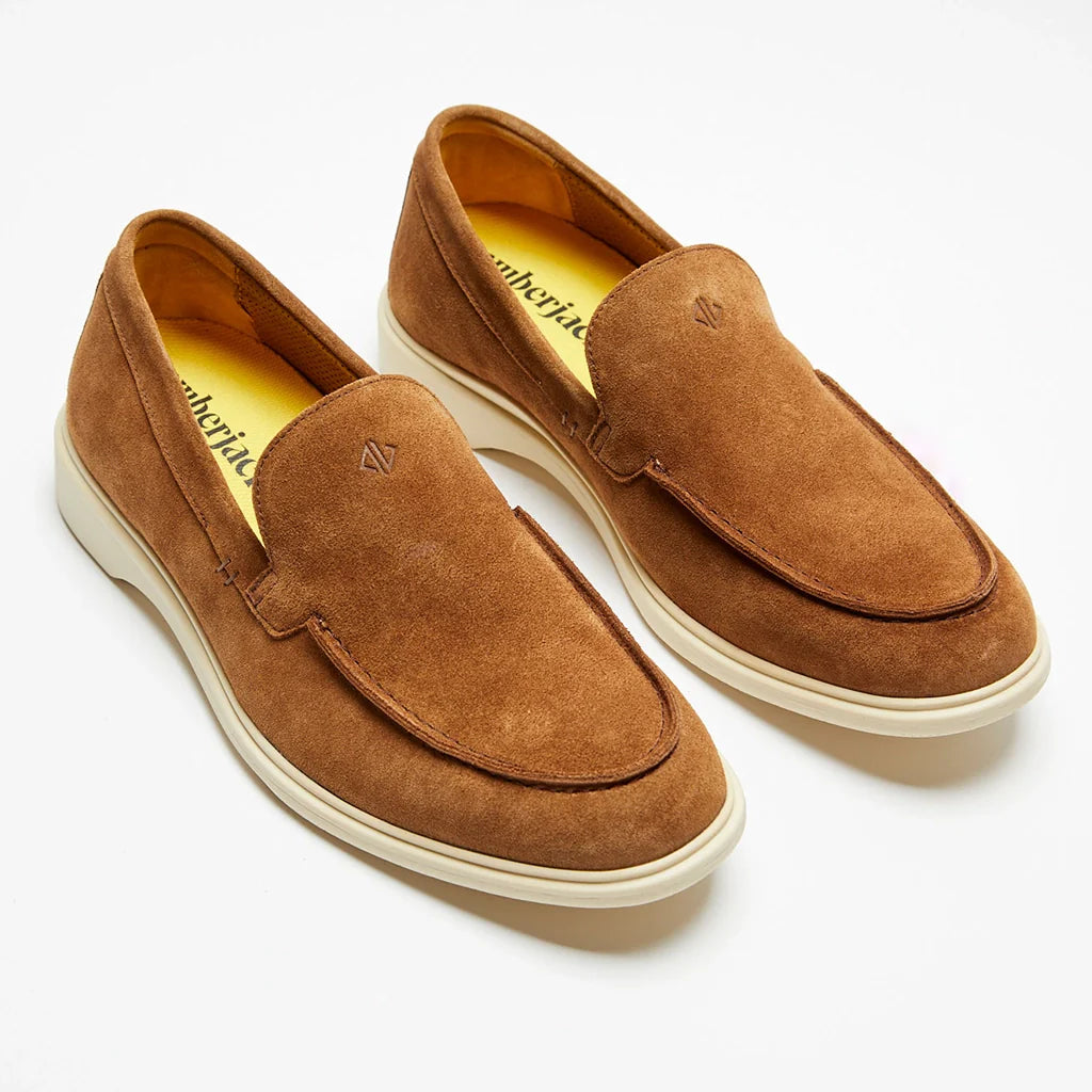 Pair of brown suede loafers on a white background