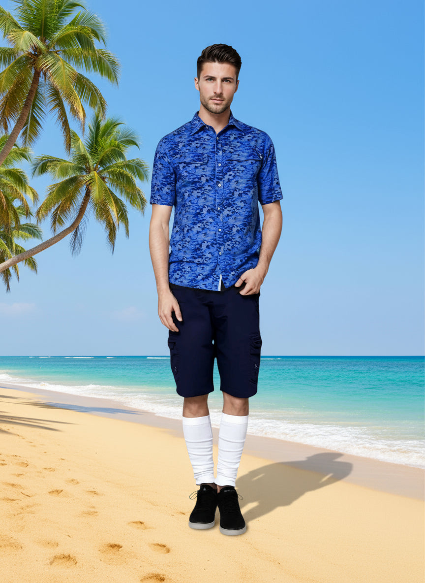 Man wearing a blue patterned shirt and navy shorts on a white background