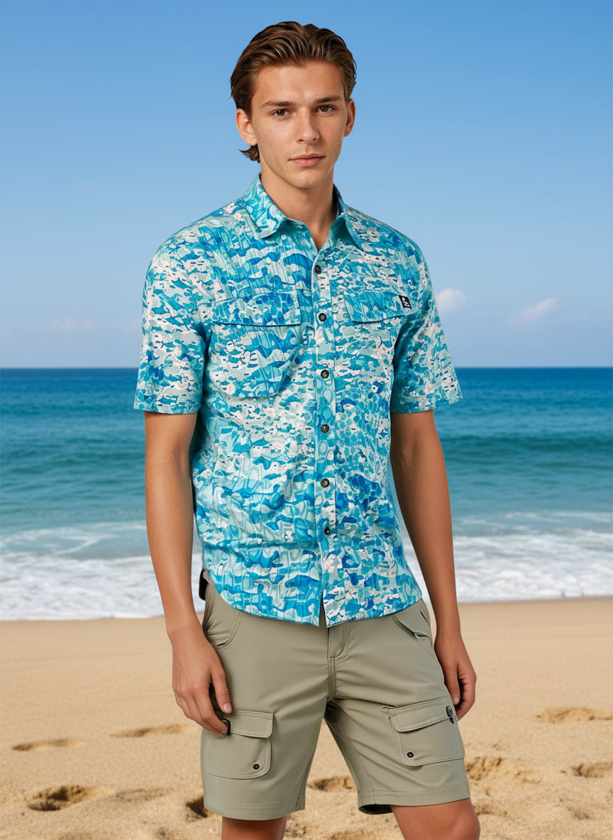 Man wearing a blue camouflage shirt and beige shorts on a white background