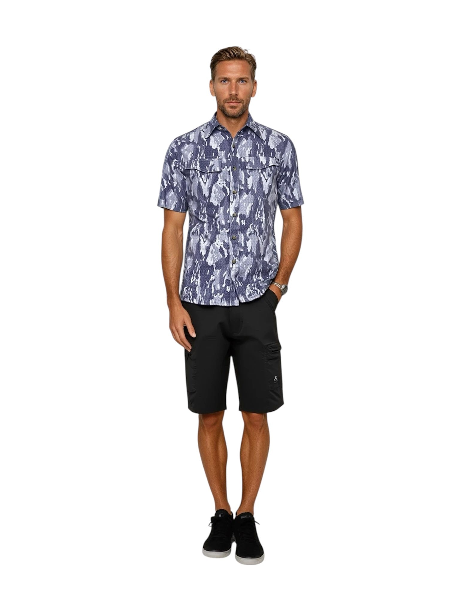 Man wearing a patterned shirt and black shorts on a white background