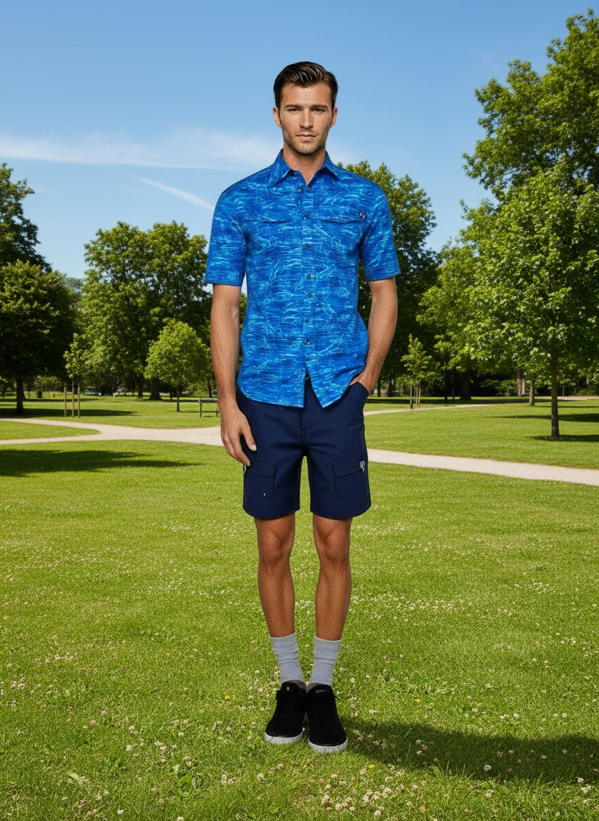 Man wearing a blue patterned shirt and navy shorts on a white background