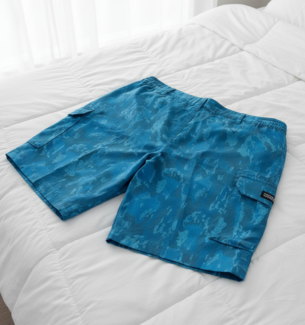 Blue camouflage shorts with a visible brand logo on a white background