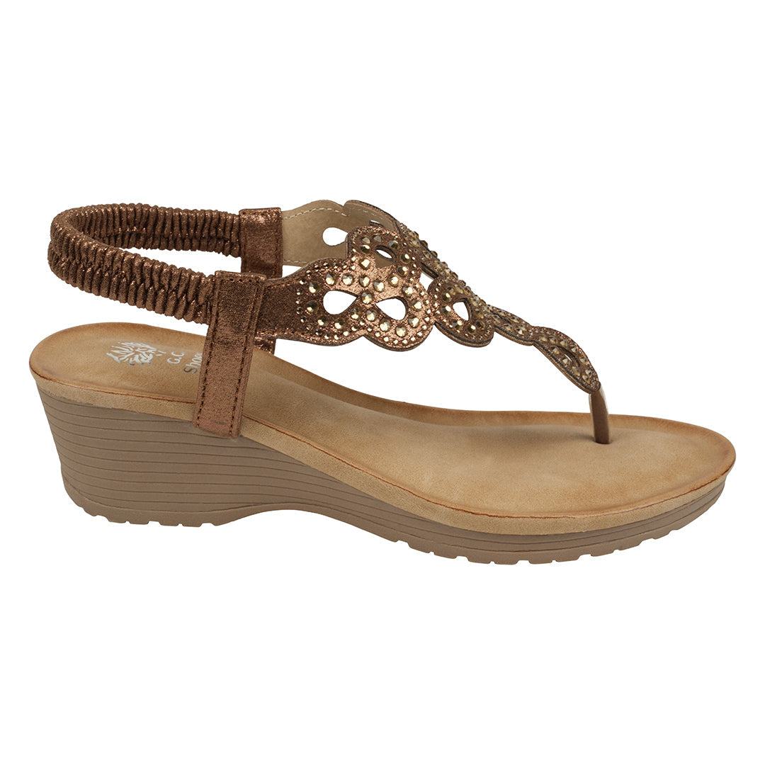 Brown wedge sandal with decorative strap on a white background