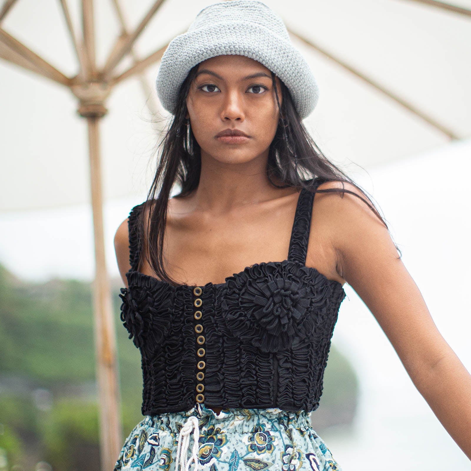 Woman wearing a black crochet top and patterned skirt outdoors