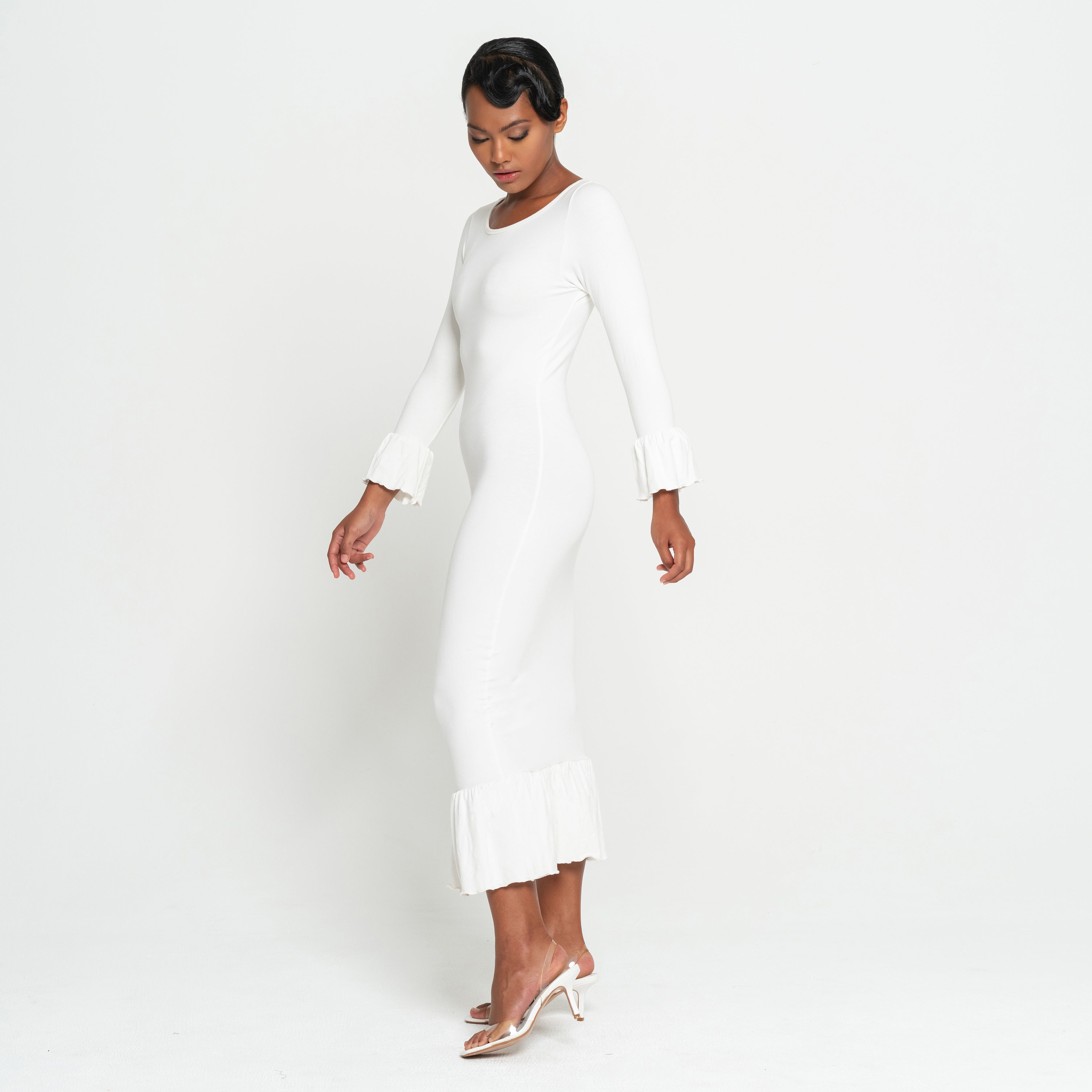 Woman wearing a white dress on a plain background