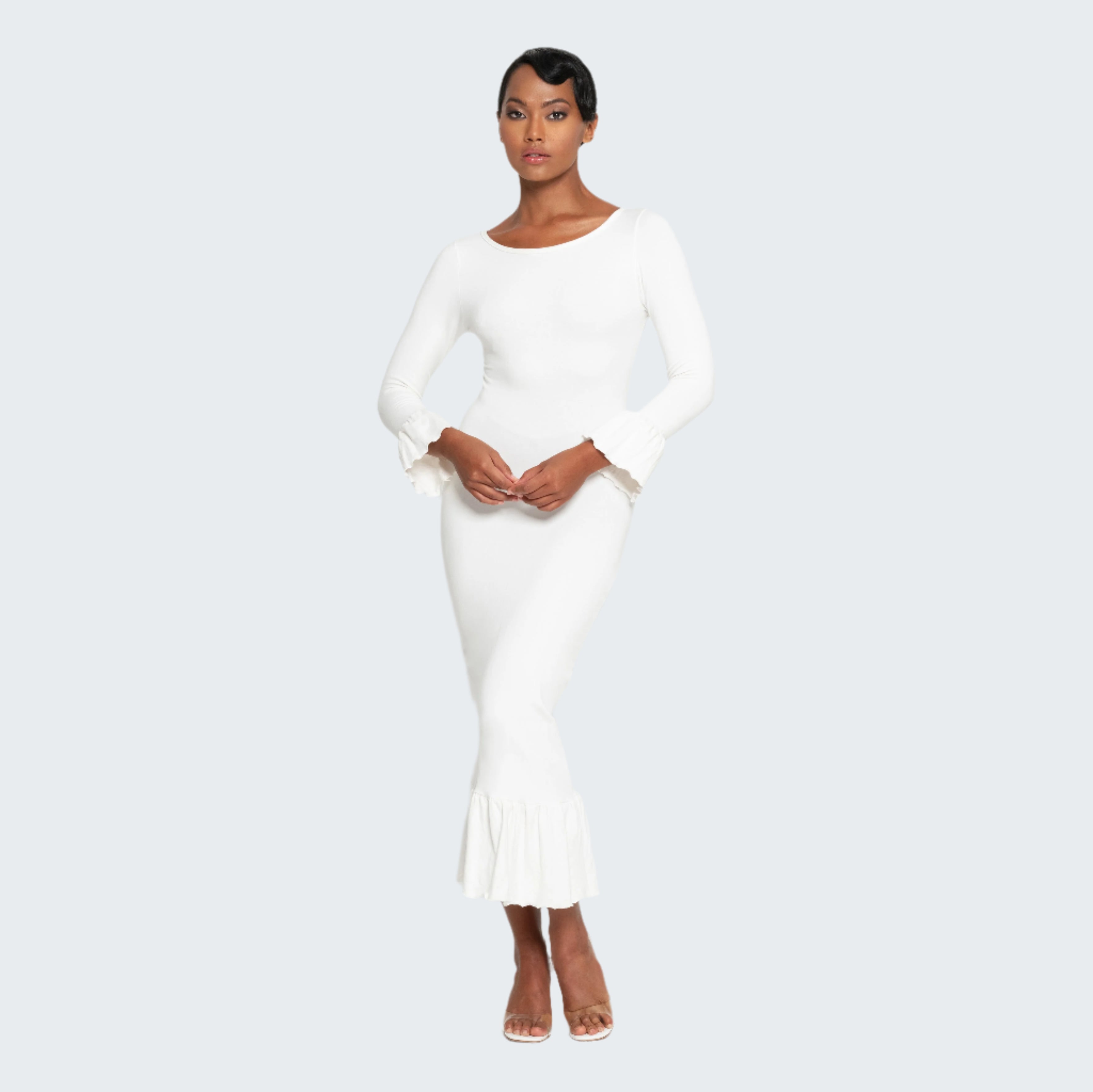 Woman wearing a white dress against a plain background