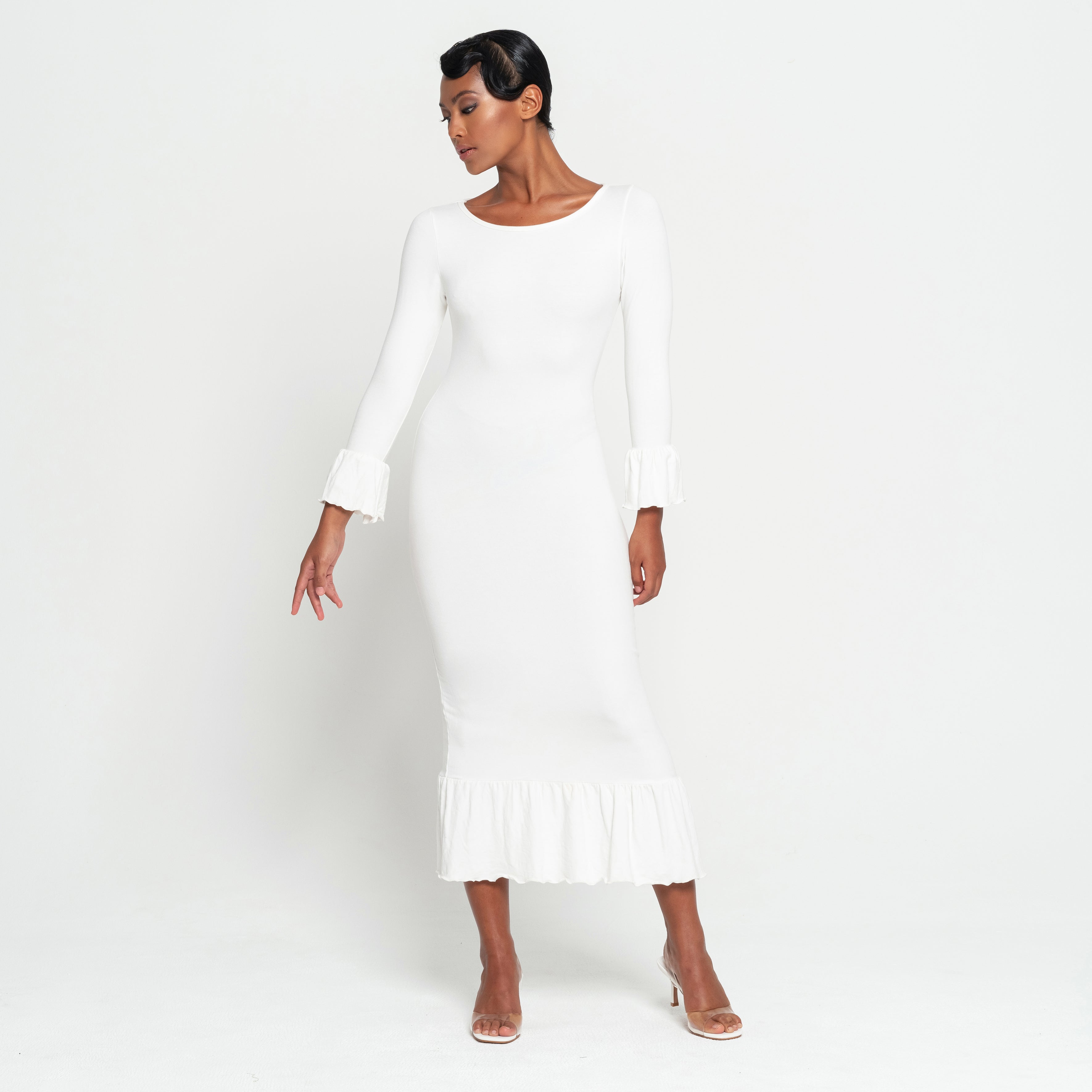 Woman wearing a white dress against a plain background