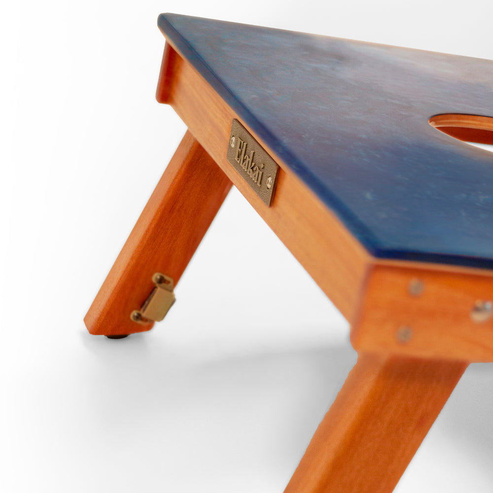 Wooden step stool with a blue top on a white background