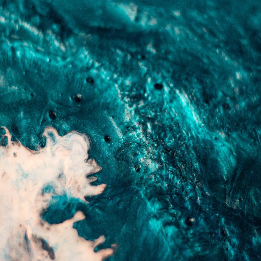 Close-up of textured blue surface with white foam