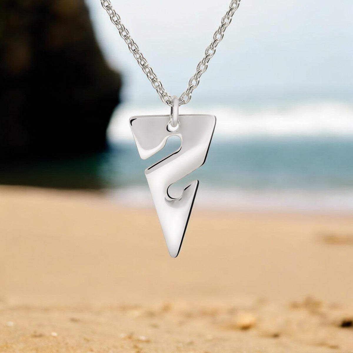Silver necklace with a unique pendant on a blurred beach background