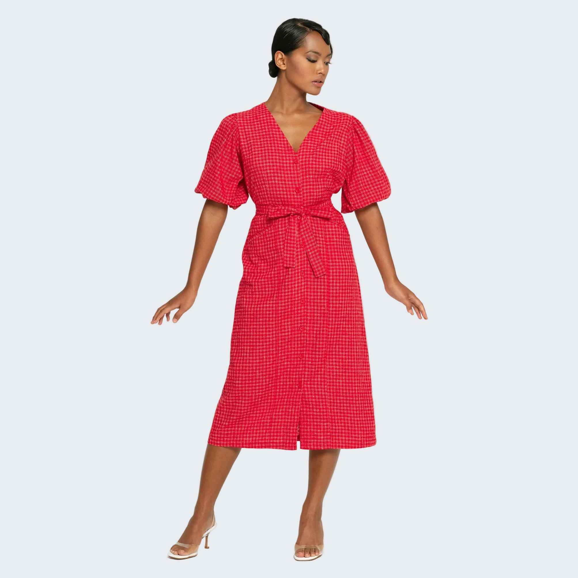 Woman wearing a red checkered dress on a white background