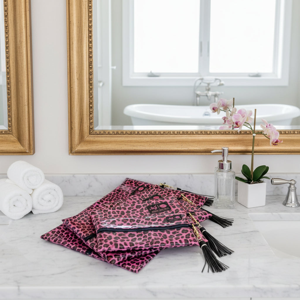 Pink leopard print bags with black tassels on a white background