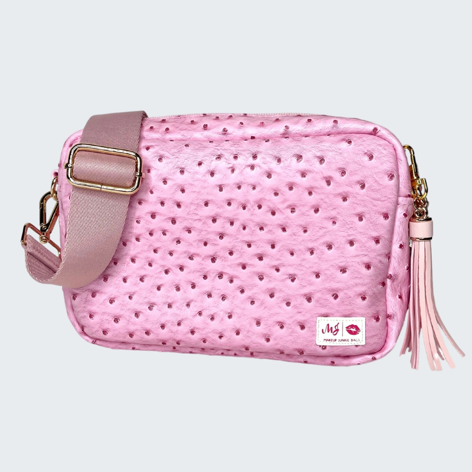 Pink textured handbag with a tassel on a white background