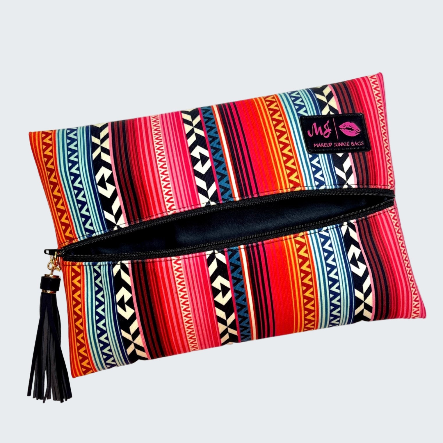 Colorful patterned clutch bag with a tassel on a white background