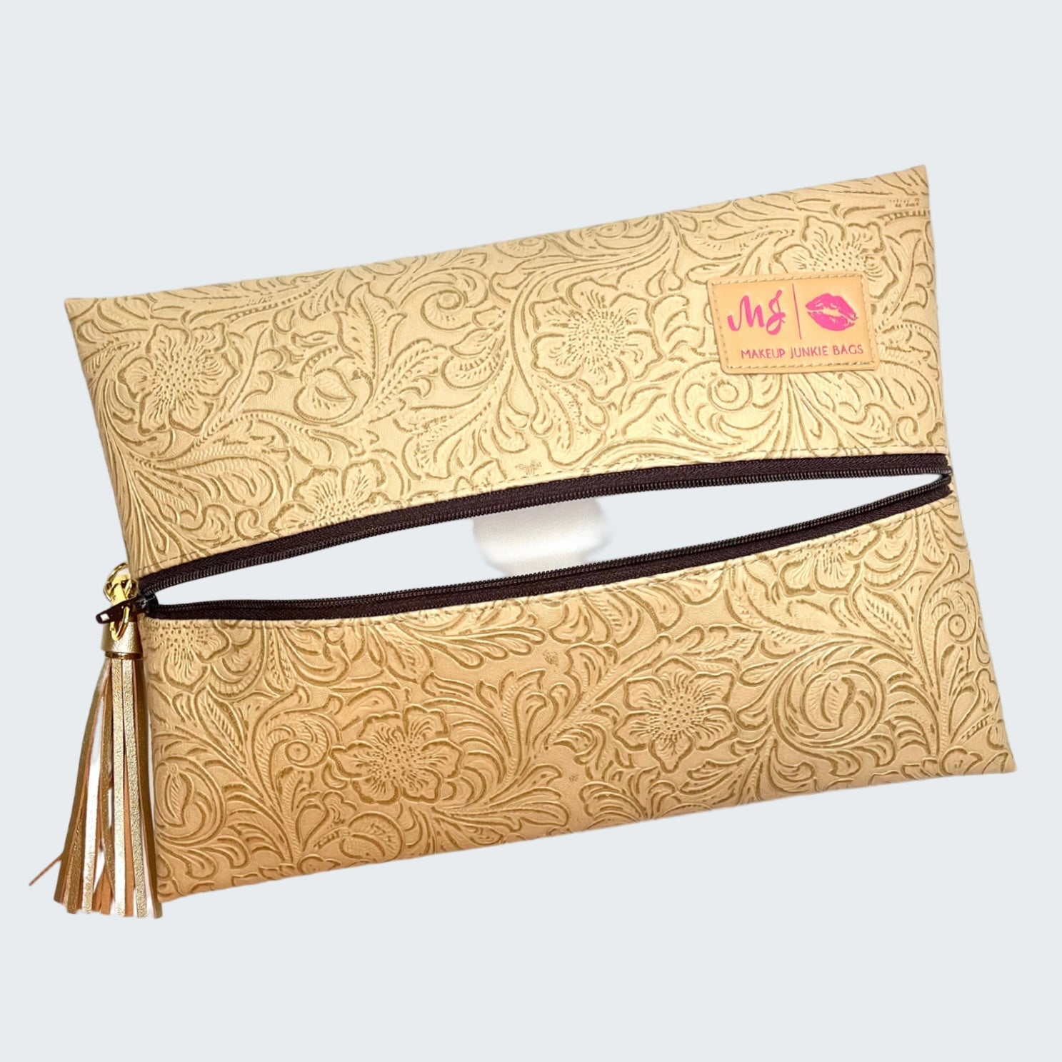 Beige clutch bag with floral pattern and visible brand label on a white background