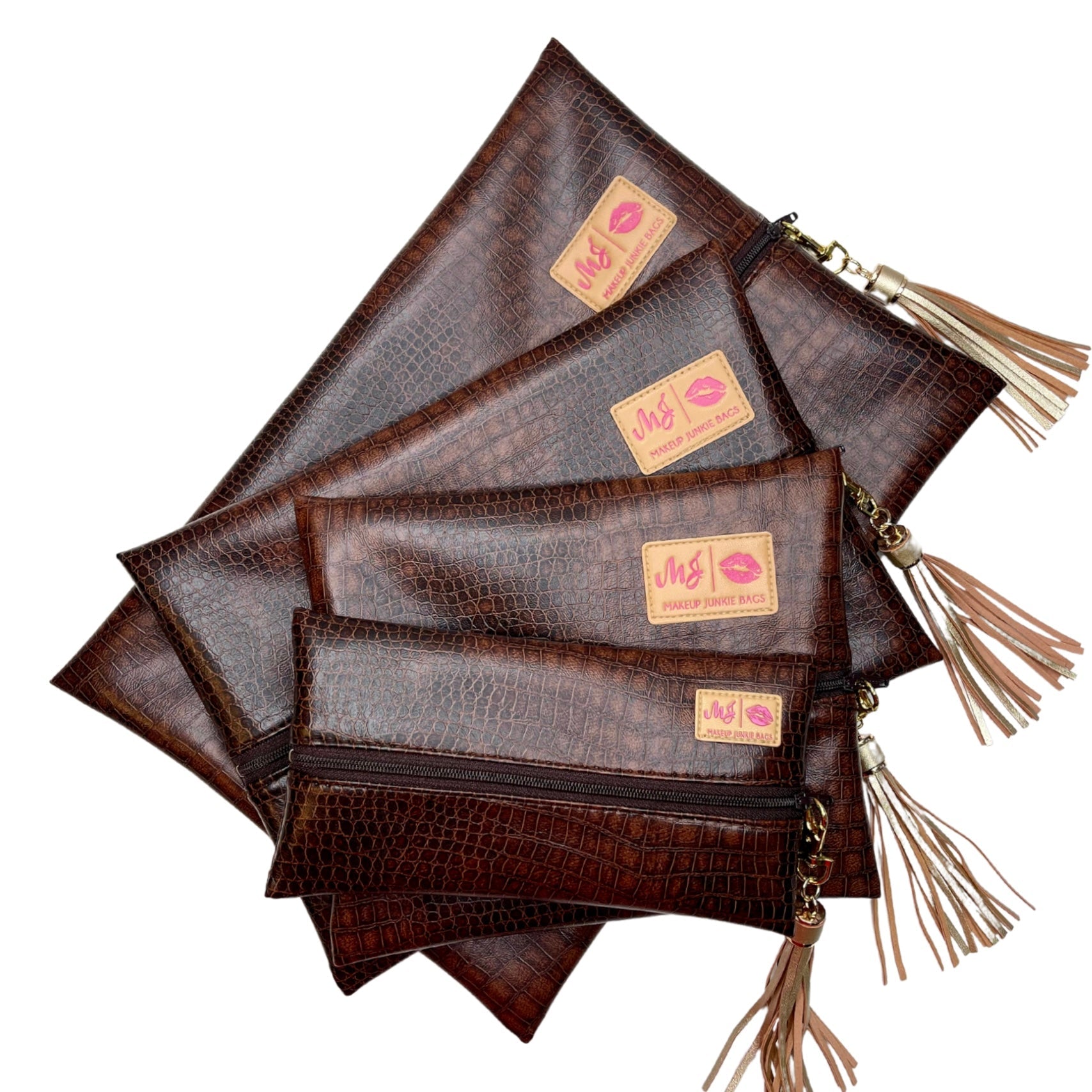 Set of brown leather pouches with tassels on a white background