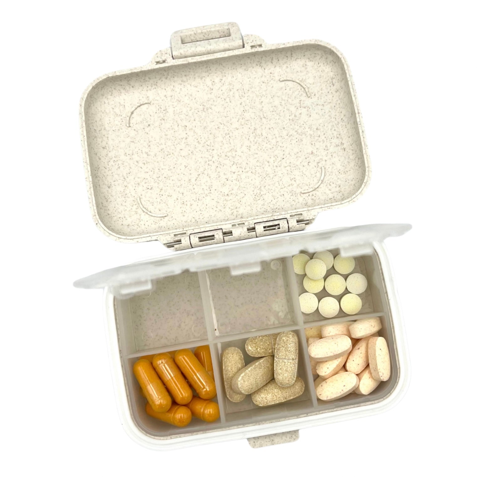 Pill organizer with compartments filled with various pills on a white background
