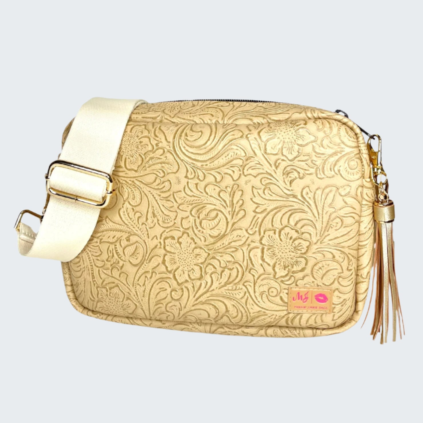 Gold patterned handbag with a tassel on a white background