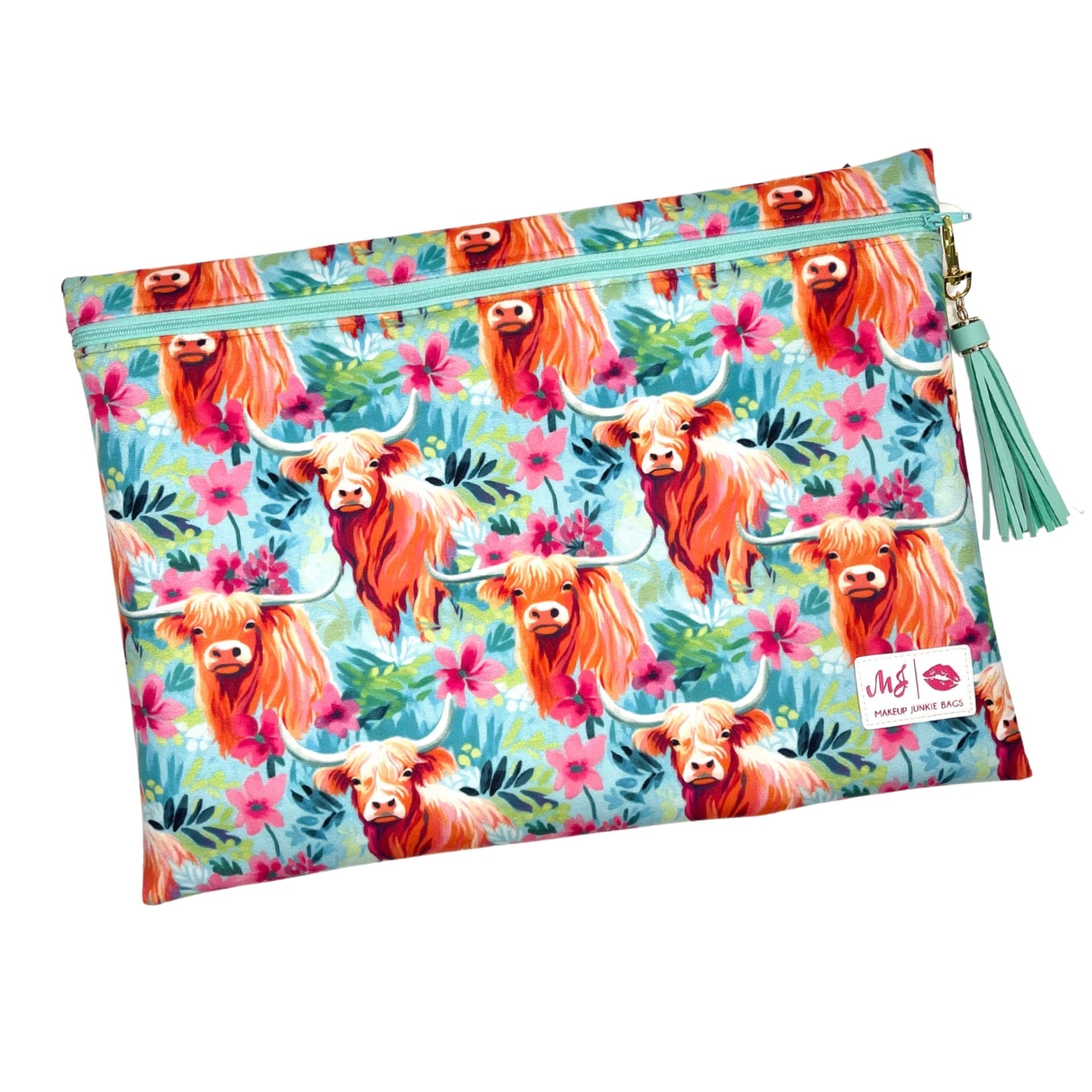 Floral and cow-patterned pouch with a tassel on a white background