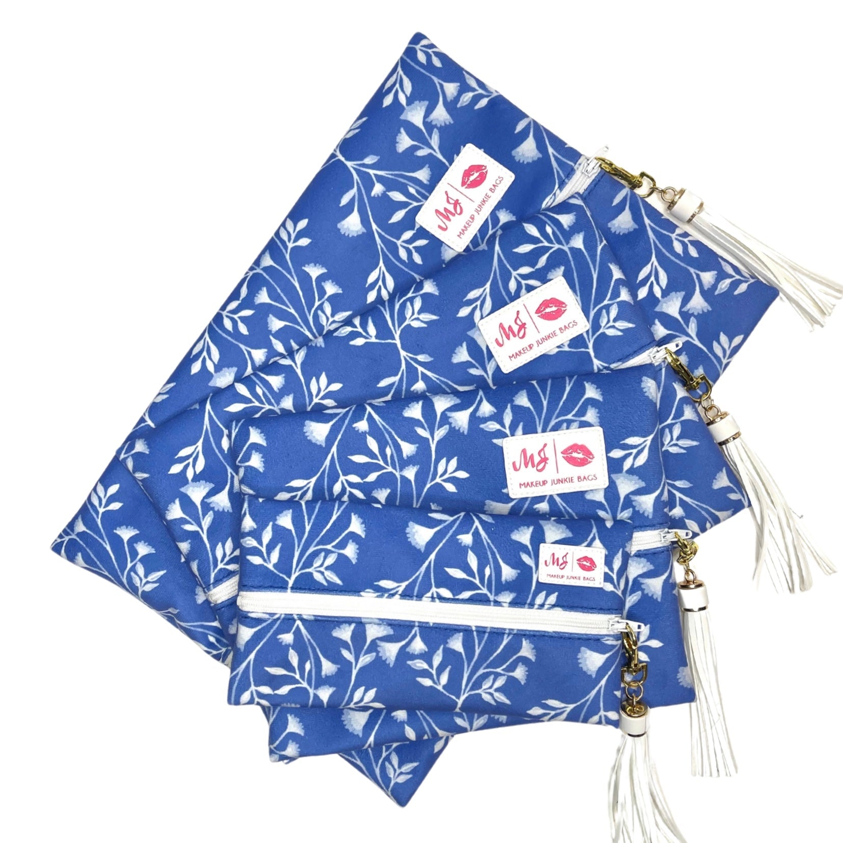 Set of blue floral pouches with white tassels on a white background