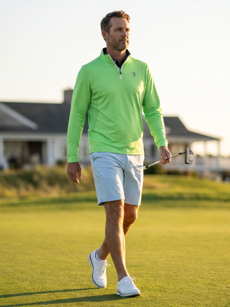 Man in a bright green golf shirt walking on a golf course with a blurred background