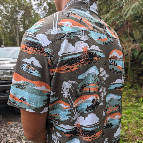 Person wearing a colorful shirt with nature-themed designs outdoors.