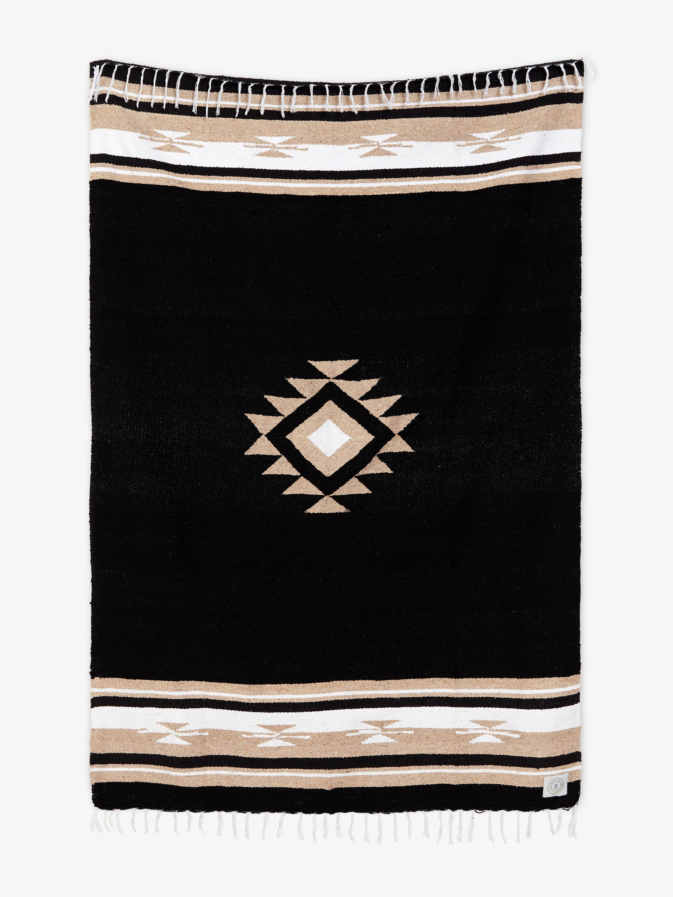 Black blanket with geometric pattern and striped border on a white background