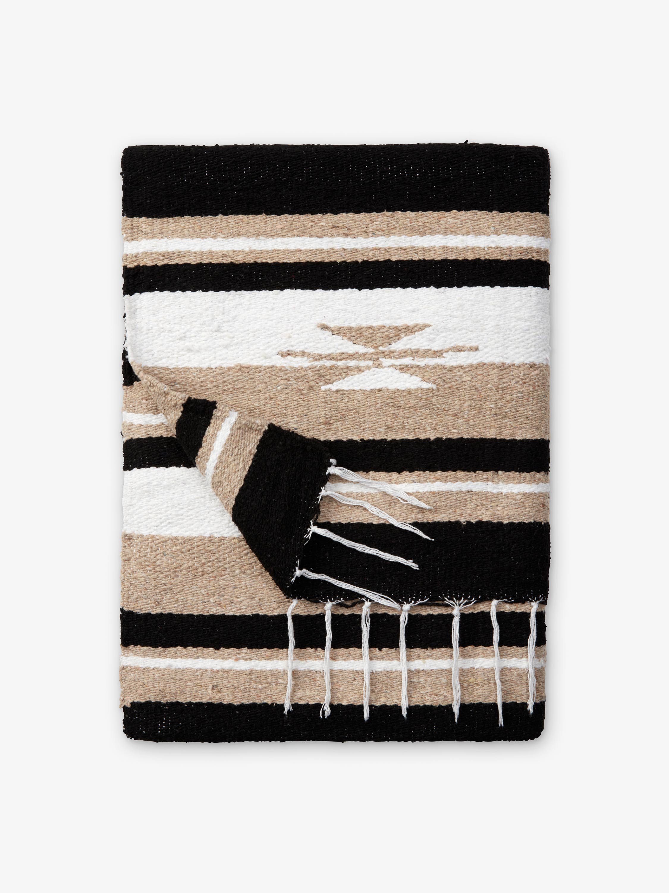 Woven blanket with black, beige, and white pattern on a white background